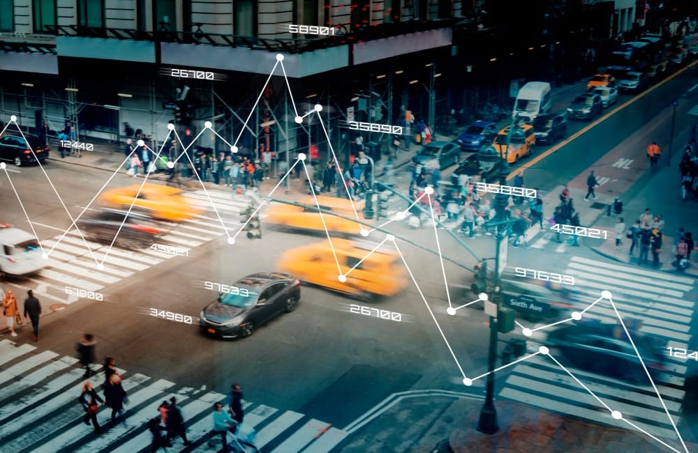 A busy city road with taxis and people