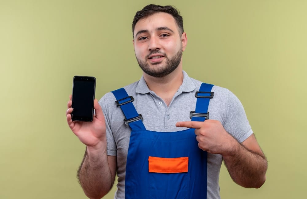 Handyman provider points a finger at his mobile 