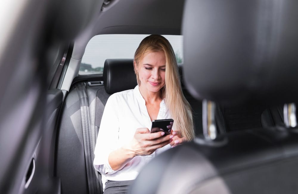 Woman with phone in car back seat